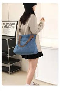 Blue canvas tote bag for women, large capacity shoulder handbag with brown handles and zipper.