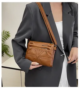 Detailed view of washed soft leather crossbody bag with multiple zipper pockets and unique panels.