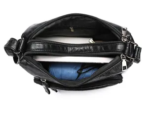 Detail view of black soft leather crossbody shoulder bag with multiple compartments.
