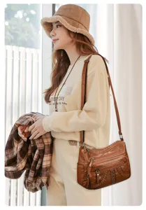 Detailed view of the stylish soft leather crossbody bag with multiple compartments and rivets.