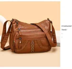 Brown soft leather crossbody bag with multi compartments, zipper pockets and metal studs.
