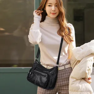 Women black soft leather crossbody bag with multi compartments and chic rivets for daily wear.