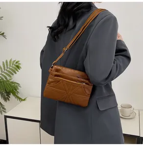 Brown washed soft leather crossbody bag with multiple zippers, perfect for daily use.