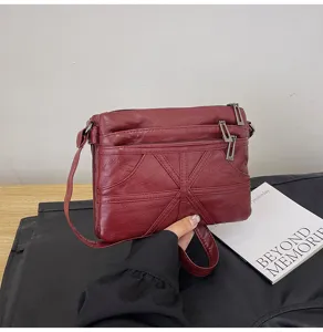 Detailed view of red washed soft leather crossbody bag, multiple zipper pockets, stylish.