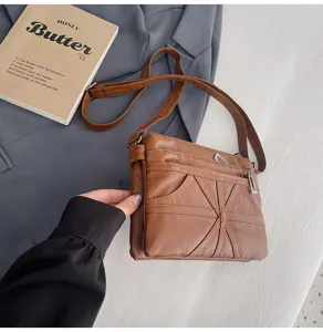 Close-up view of the washed soft leather crossbody bag showing multi-pocket design and zippers.