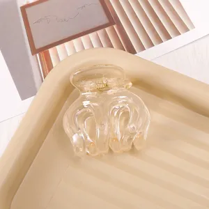Transparent plastic hair claw clip with spring for secure daily hairstyling and ponytail accessory.