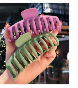 Matte large hair claw clip detail view showing dual purple and green colors for styling.
