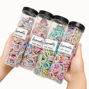 Colorful kids hair ties in transparent storage tubes, elastic rubber bands for daily styling.