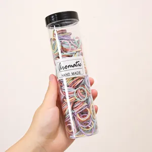 Close-up view of colorful small hair ties inside a clear bottle for daily styling.