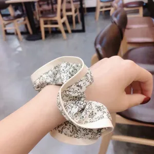 Korean style floral fabric hair scrunchie detail shot, elegant wrist accessory and hair tie.