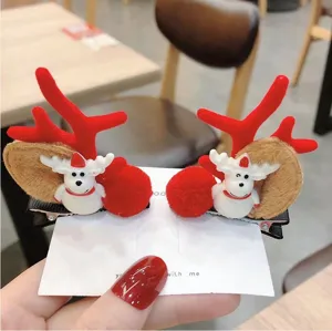 Detalle de la bonita pinza de pelo de reno navideño con astas de felpa y figura blanca.