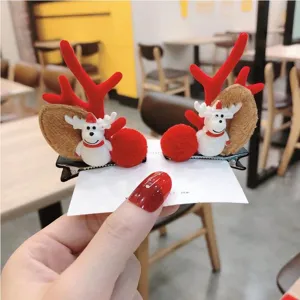 Detalle de pinces para el cabello de reno navideño con bonitos cuernos de peluche y ciervo.