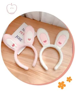 Dettaglio cerchietto con lunghe orecchie di coniglio in peluche, morbide e ricamo cuore.