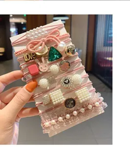 Detail view of the cute pink hair tie set featuring pearls, crystals, and lovely charms.
