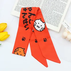 Orange ribbon hair scarf with cute cat print and Japanese text. Soft silk feel hair accessory.