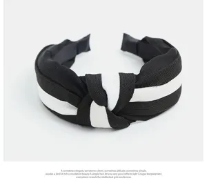 Detail shot of black white fabric knotted headband, wide brim design, elegant daily hair accessory.