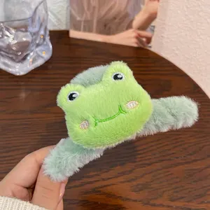 Primer plano de una pinza de pelo de felpa de rana verde con bonitos detalles bordados.