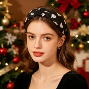 Black knotted headband with white ghost print, stylish fabric hair accessory for women.