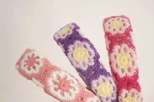 Detailed view of colorful knitted floral crochet headbands, bohemian style hair accessories.