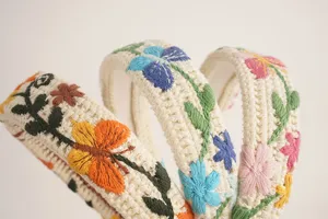 Gros plan détail du serre-tête en tricot brodé bohème avec motifs floraux et papillons.