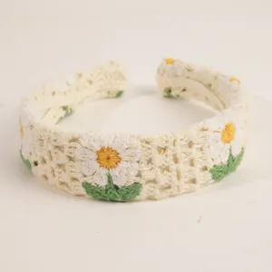 Gros plan sur le serre-tête en crochet marguerite fait main, détails accessoire cheveux boho.