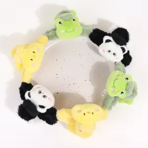 Detalle de pinza de pelo de felpa con lindos diseños de panda rana y pollito de textura suave.