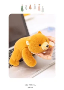 Detailed view of a cute plush brown bear toy resting on a laptop keyboard in a cozy setting.