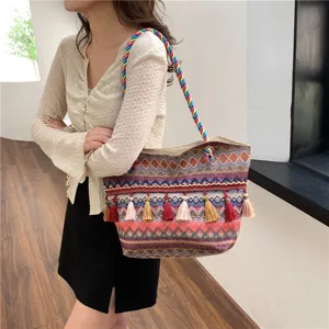 Ethnic style woven tote bag detail showing colorful geometric patterns and stylish hanging tassels.