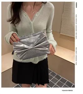 Silver metallic bow clutch bag for women, stylish evening purse for party and daily fashion look.