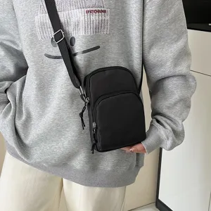 Small black nylon crossbody bag for women, simple casual phone pouch with front zipper pocket.