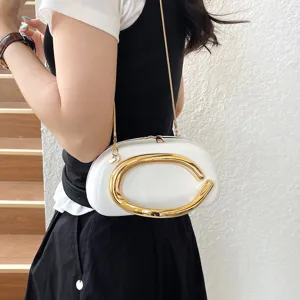 Detailed view of white shoulder bag featuring metallic gold chain and artistic C-shaped handle.