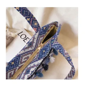 Detailed close-up view of ethnic woven tote bag featuring zip closure and colorful tassels.