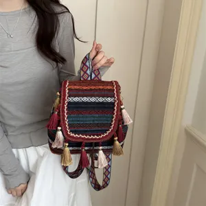 Ethnic style woven backpack with colorful geometric patterns and decorative tassels for women.