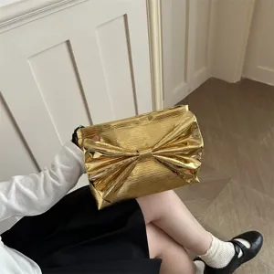 Gold metallic clutch bag for women, featuring a chic large bow design for evening parties.