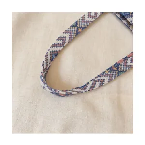Detailed shot of ethnic woven handbag strap with colorful geometric jacquard pattern.