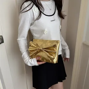 Stunning gold metallic bow clutch bag for women, elegant evening party handbag with chic design.