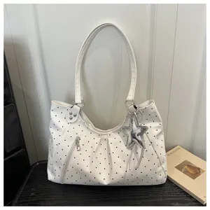 White polka dot shoulder bag detail, stylish commuting tote with silver star pendant and zipper.