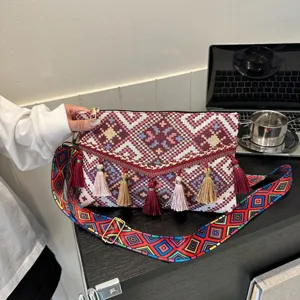 Ethnic style woven crossbody bag with colorful tassels, fashionable envelope shoulder bag for women.