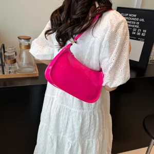 Pink patent leather shoulder bag detail view showing elegant underarm hobo style and glossy finish.