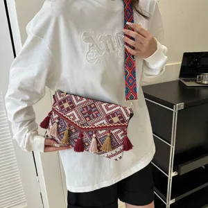 Ethnic style women envelope shoulder bag with colorful woven strap and vintage tassel design.