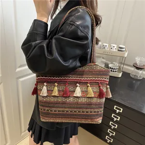 Ethnic woven tote bag with colorful tassels, fashionable and spacious shoulder bag detail.