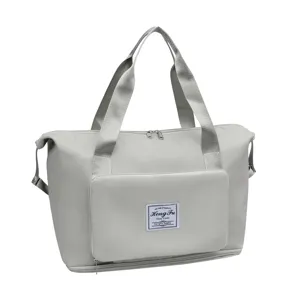 Detailed close-up view of grey foldable travel duffel bag front pocket and durable handles.