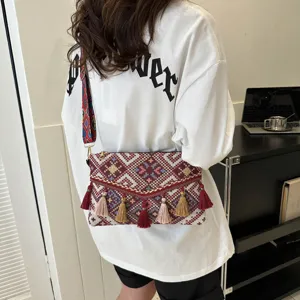 Detailed view of bohemian ethnic style woven crossbody bag with colorful strap and tassel details.