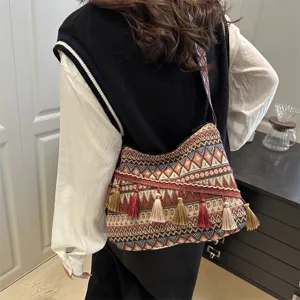 Ethnic style tassel shoulder bag detail, featuring geometric striped pattern and fringe charms.
