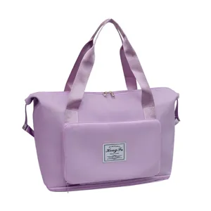 Purple travel duffel bag front pocket detail showing custom brand patch and durable fabric.