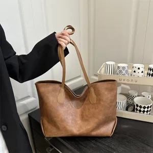 Detail view of a vintage brown PU leather tote bag, showing texture and handle details.