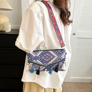 Boho woven crossbody bag with colorful geometric patterns, stylish fringe tassels, and wide strap.