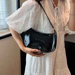 Detailed shot of black patent leather underarm shoulder bag showcasing texture and sleek design.