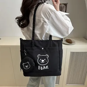 Detail shot of the black canvas tote bag featuring cute bear print and matching coin purse.