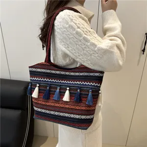 Detail view of ethnic colorful woven tote bag with fringe tassels, stylish shoulder strap.